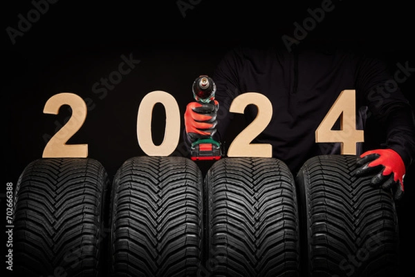 Fototapeta Car tires service and hands of mechanic with wheels screwdriver, 2024 happy new year background