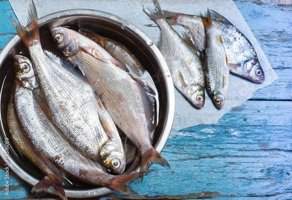 Obraz fresh fish in  iron bowl on a wooden background