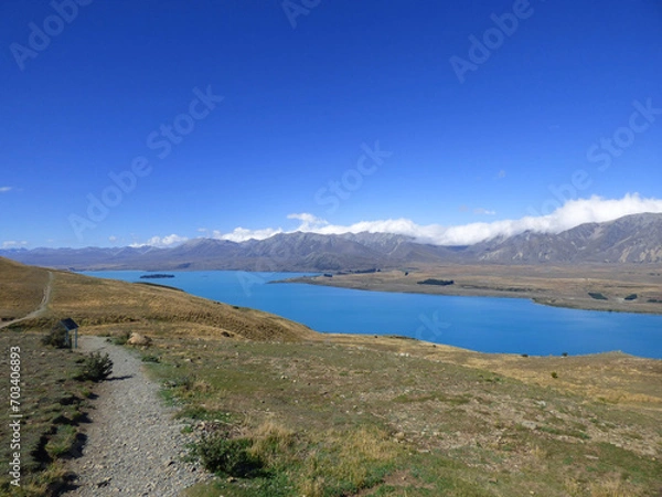 Fototapeta Lake Tekapo viewed from Mt. John Observatory. Clear blue waters in the summer. New Zealand South Island, Aoraki National park. Mountains in the background.