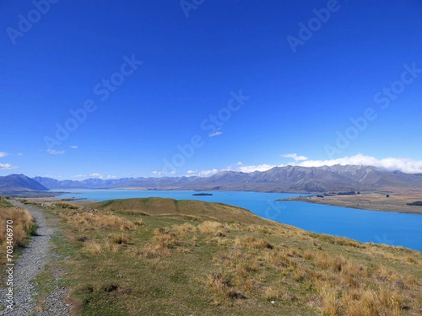 Fototapeta Lake Tekapo viewed from Mt. John Observatory. Clear blue waters in the summer. New Zealand South Island, Aoraki National park. Mountains in the background.