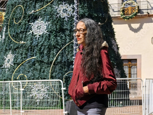 Fototapeta A lady walking through downtown Queretaro in winter wearing a jacket