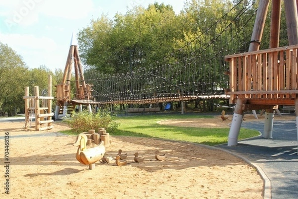 Obraz Wooden playground made of natural eco-friendly material in public city park. Modern safety children outdoor equipment. Concept of sustainable lifestyle and ecology. Children rest and games on open air