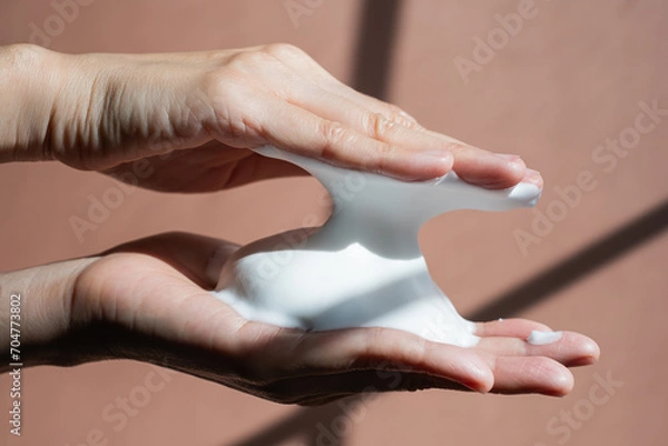 Fototapeta Close up hand with creamOK foam for facial cleanser and cleansing make up. Beauty and cosmetic concept.