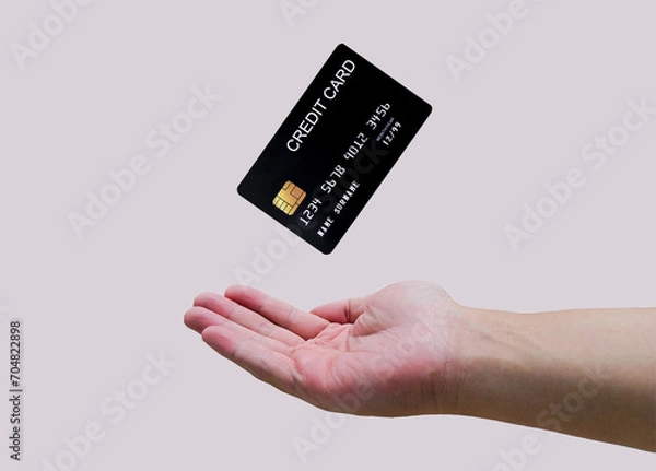 Fototapeta Man hand and black credit card mockup floating, used for online shopping and online transactions. isolated on grey background