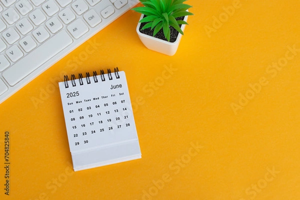 Fototapeta June 2025 desk calendar on yellow background. Directly above. Flat lay.