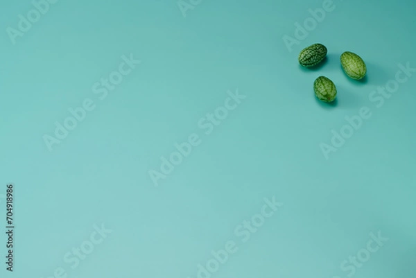 Obraz マイクロきゅうりを数粒右上に配置した緑色系背景あり俯瞰撮影