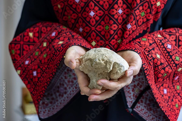 Fototapeta A Palestinian woman holds a stone in her hands, which represents the only weapon to resist the occupation