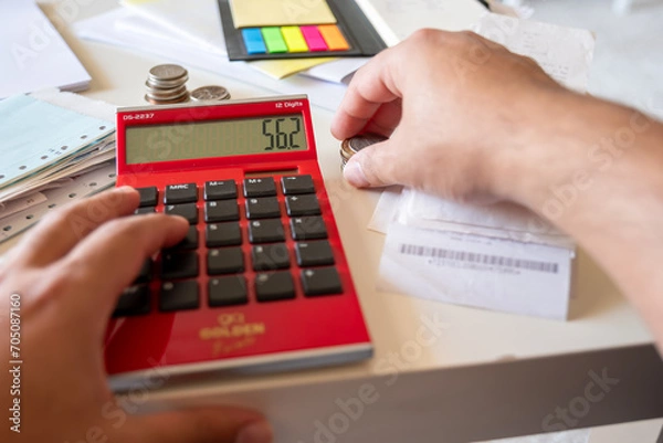 Fototapeta Hands of man with financial bills calculating with calculator