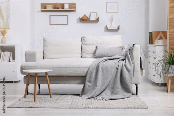 Fototapeta Grey plaid on comfortable sofa in living room