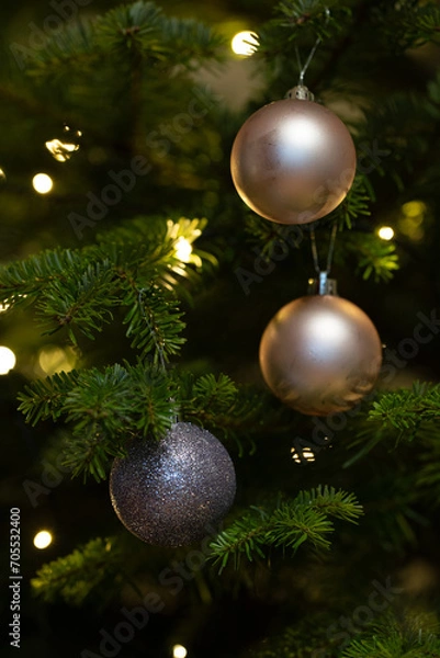 Obraz Close-up of Christmas balls hanging on a tree with Christmas lights in the background. 