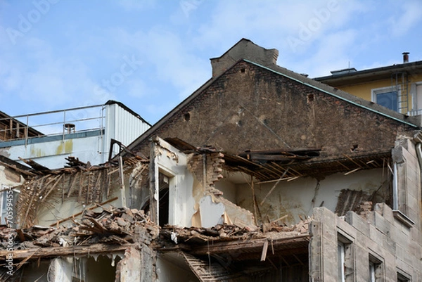 Fototapeta The construction site with the dismantling of the walls of the building on the street of the city. Reconstruction and renovation of cities