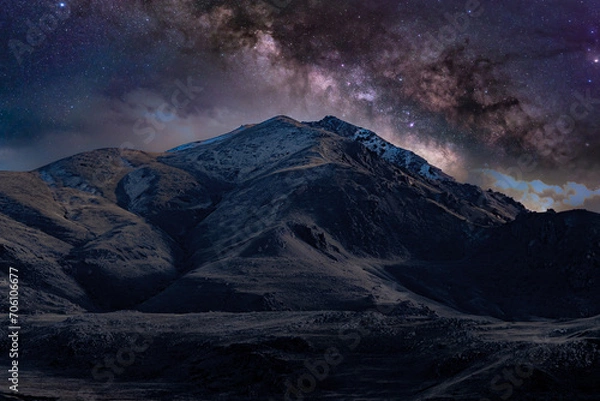 Fototapeta Milky Way galaxy over a snow-capped mountain