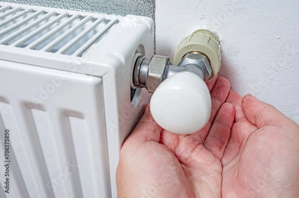 Obraz Person holding water from leaking heating radiator in his palms. Defective heater. Water pours from the threaded connection of the heating pipe. The need for plumbing work.