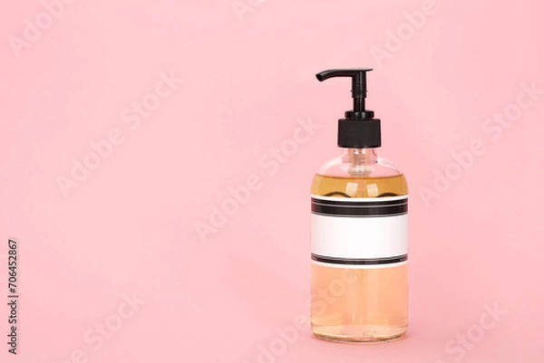 Fototapeta Dispenser for lotion, bath foam or hand soap isolated on a pink background.