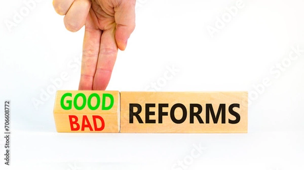 Fototapeta Good or bad reforms symbol. Concept words Good reforms Bad reforms on beautiful wooden blocks. Beautiful white table white background. Businessman hand. Business good bad reforms concept. Copy space