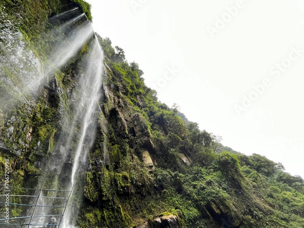 Fototapeta Looking up at a majestic waterfall in the jungle of Colombia
