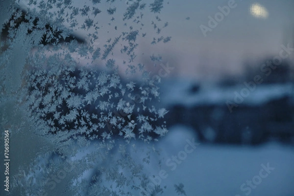Fototapeta The abstract creation of window frost on window glass. Ornamental floral frost shapes on the window. Frost flowers