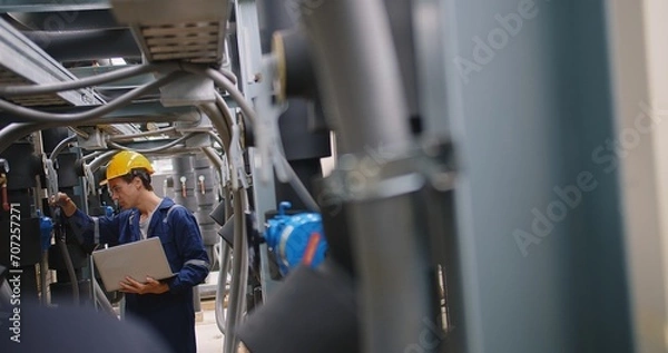 Obraz engineer using laptop checking industry cooling air conditioner water cooling tower air chiller of large industrial building to control air system at construction site