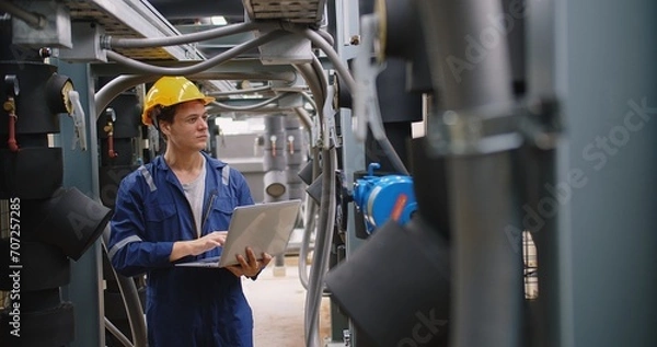 Obraz engineer using laptop checking industry cooling air conditioner water cooling tower air chiller of large industrial building to control air system at construction site