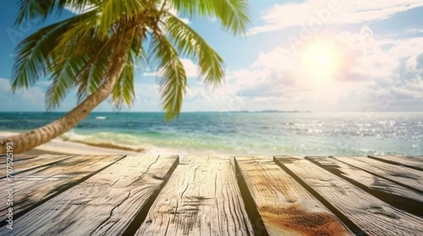 Fototapeta Summer holiday concept: Wooden table with coconut palm tree at the beach background