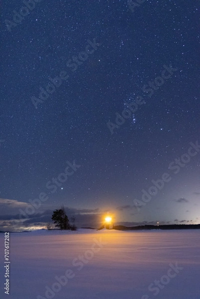 Fototapeta winter time starry sky over the lighthouse