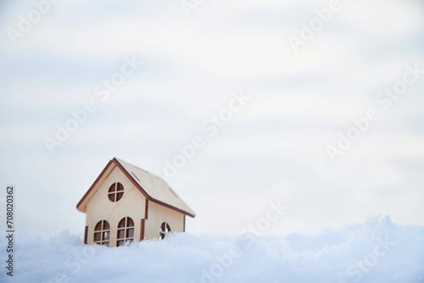 Fototapeta Wooden toy house on snow, natural abstract background. winter season concept. Christmas and new year holidays. symbol of cozy, loving family home. construction, sales, rental concept. copy space