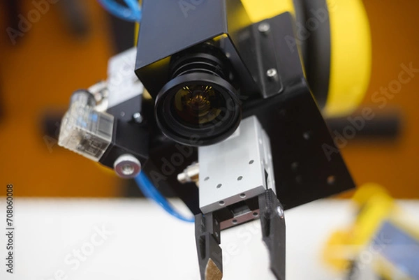 Fototapeta A robot in a factory equipped with a machine vision camera.