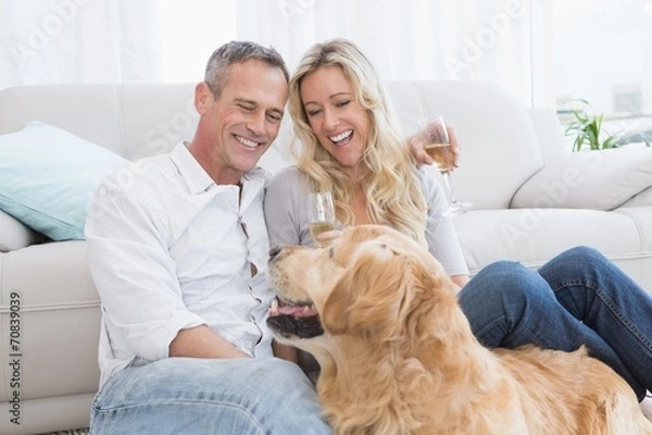 Fototapeta Couple drinking champagne with their dog in front of them
