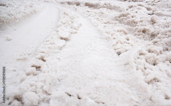 Fototapeta Tracks from a passing car, on the snow. A car drove through the white snow