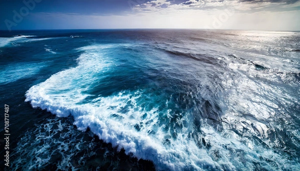 Obraz An aerial view shows ocean waves against a blue water background.
