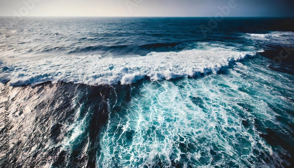 Obraz An aerial view of ocean waves with a blue water background.