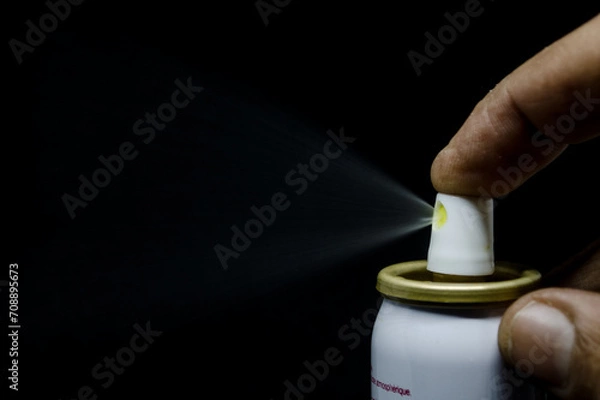 Obraz Close up view of a man spraying, A spray can  in a hand on a black background