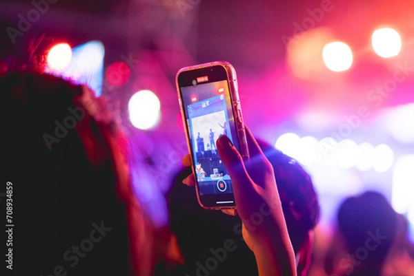 Fototapeta People holding smart phone and recording and photographing in music festival concert, event background concept