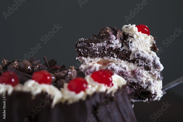 Fototapeta Portion of chocolate and cream cake, being served.