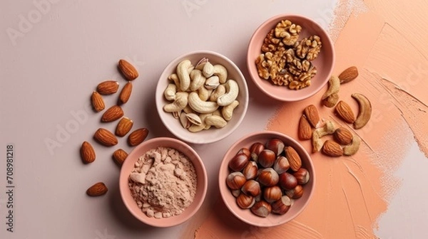 Fototapeta  three bowls filled with nuts on top of a pink counter top next to a bowl of almonds and a bowl of powdered almonds on a pink surface.