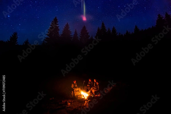 Obraz Group of people near the fireplace in the night forest