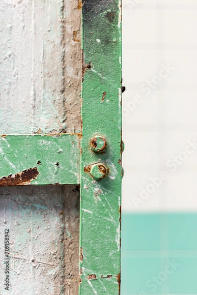 Obraz Detail of a pillar with a green steel frame affected by rust in an old abandoned factory.
