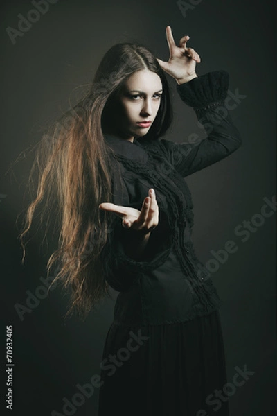 Fototapeta Beautiful young witch casting a spell