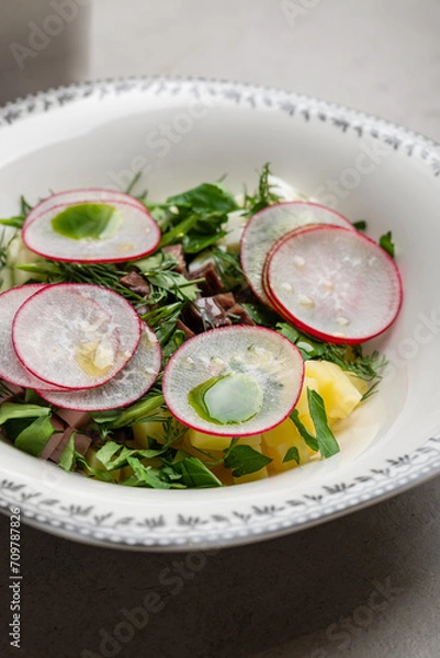 Obraz Traditional cold Russian okroshka soup close-up. A mix of beef, vegetables, herbs, eggs and kvass. Restaurant serving