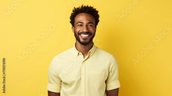 Obraz A young man with a radiant smile and casual shirt emanates warmth and confidence, making it a perfect shot for representing friendly customer service or approachable leadership.