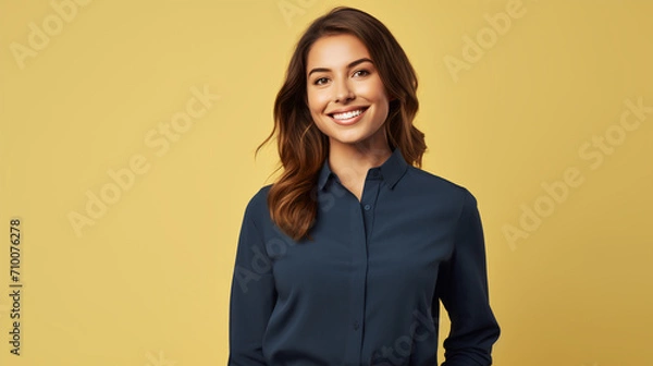 Obraz A woman with a warm smile is featured against a soft yellow background, wearing a smart navy blue blouse. The image suitable for corporate or casual business representation.