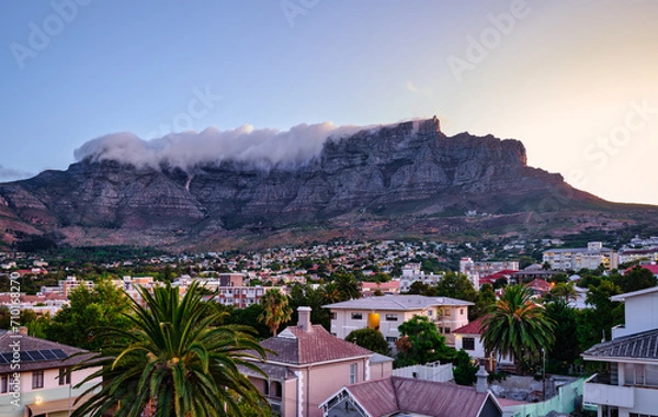 Fototapeta Table Mountain peak covered with cloud and suburb nestled on the foothills of Table Mountainat during sunset, Cape Town, South Africa