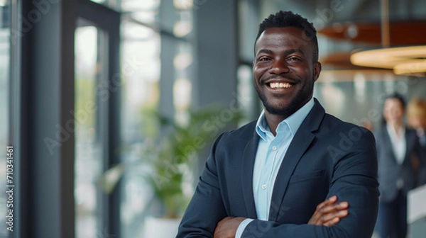 Fototapeta Portrait of a handsome smiling black businessman boss standing in his modern business company office.