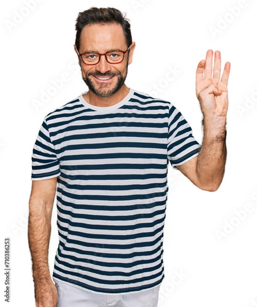 Obraz Middle age man wearing casual clothes and glasses showing and pointing up with fingers number four while smiling confident and happy.