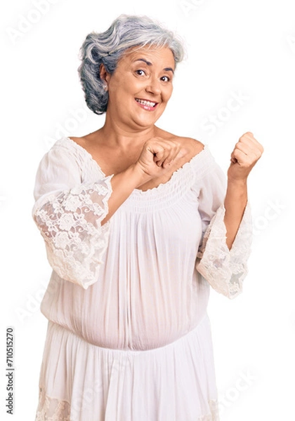 Obraz Senior woman with gray hair wearing bohemian style pointing to the back behind with hand and thumbs up, smiling confident