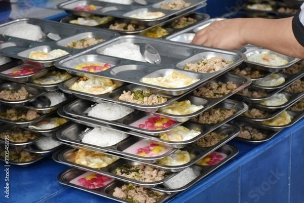 Fototapeta Various foods on stainless steel trays are arranged neatly on top of each other.