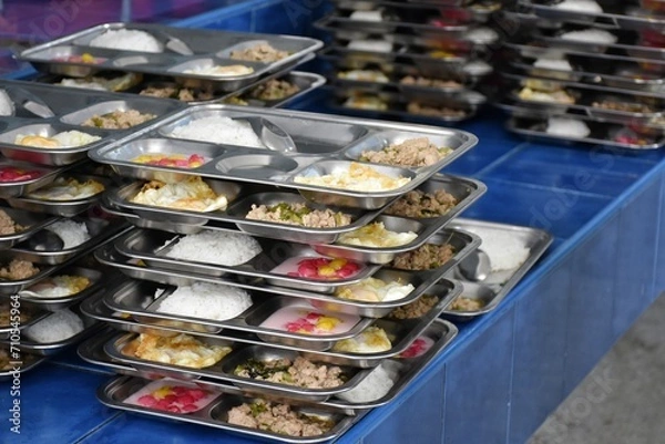 Fototapeta Various foods on stainless steel trays are arranged neatly on top of each other.