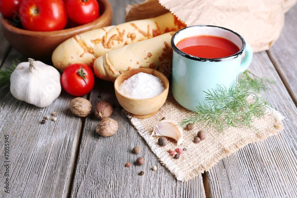 Fototapeta Homemade tomato juice in color mug, bread sticks, spices and