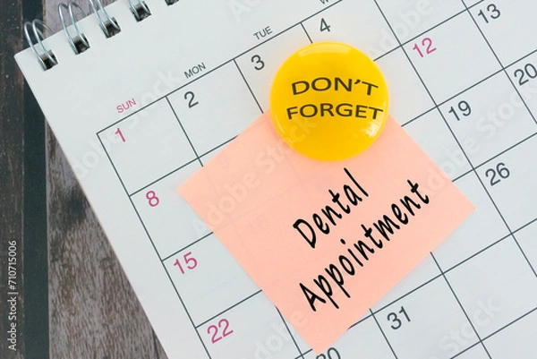 Fototapeta Dental Appointment text on orange paper sticky note with yellow magnet.
