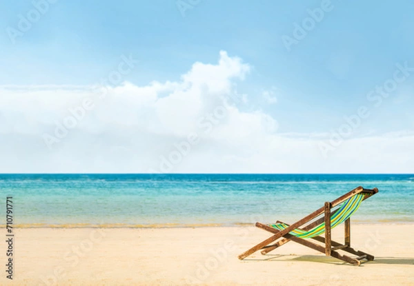 Fototapeta Lounge chairs on a tropical beach at summer